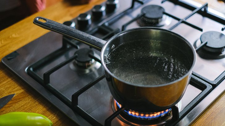 ガスコンロにかけた鍋で湯を沸かしている様子