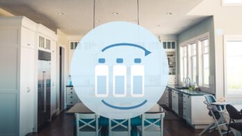 キッチンの写真を背景にペットボトルと循環矢印を描いたイラスト（水の賞味期限の記事）