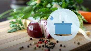 野菜とまな板の写真を背景に鍋と湯気を描いたイラスト（料理と硬度の記事）