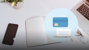 白い机の写真を背景にクレジットカードと通帳を描いたイラスト（支払い方法の記事）