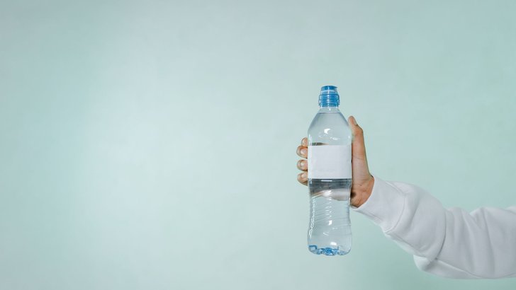 水の入ったペットボトルを手に持っているところ