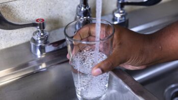 蛇口からグラスに水を注ぐ手元（浄水型ウォーターサーバー比較記事のアイキャッチ）