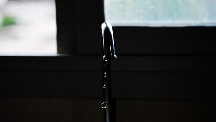 蛇口の先から水滴が落ちようとしている様子