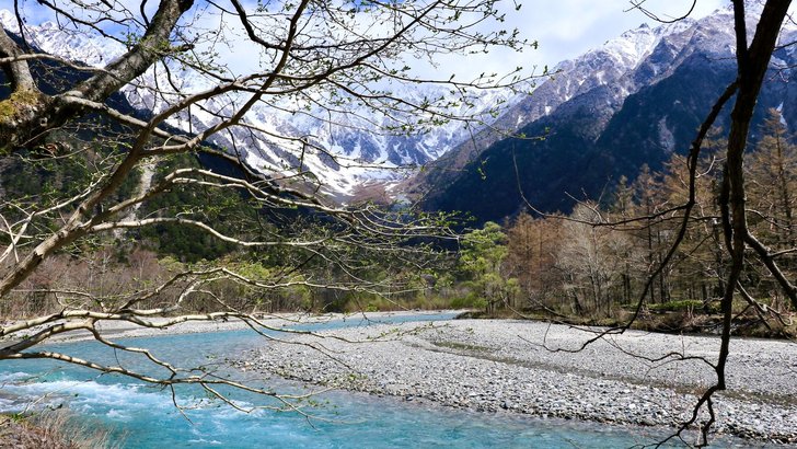 雪の残る山あいを流れる澄んだ川