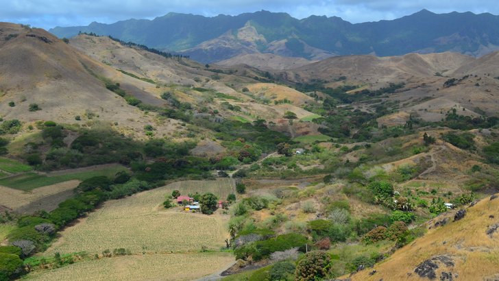 採水地ヤンガラ渓谷のあるフィジー・ラ州の谷。農地と集落の先に雨を受ける山並みが連なる