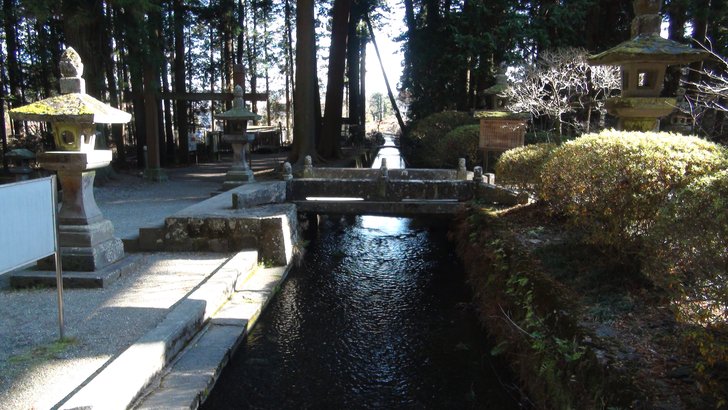 北口本宮冨士浅間神社の境内を流れる水路。杉の巨木と石灯籠の間を澄んだ水が流れる