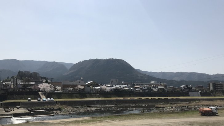 玖珠町の玖珠盆地を流れる玖珠川と、奥にテーブル状の頂をもつ伐株山