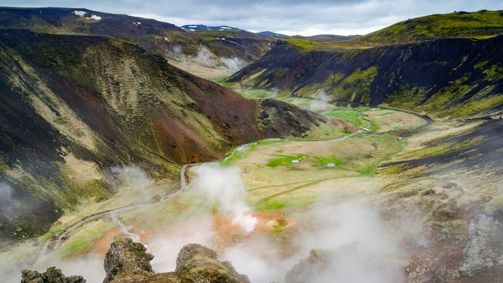 オルフス自治体のレイキャダールル渓谷。緑の谷に湯気が立ちのぼる火山の島の風景
