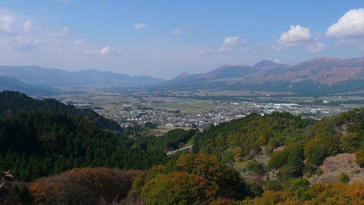 高森峠から望む南郷谷。田園と集落が広がり、その先に阿蘇の山並みが続く