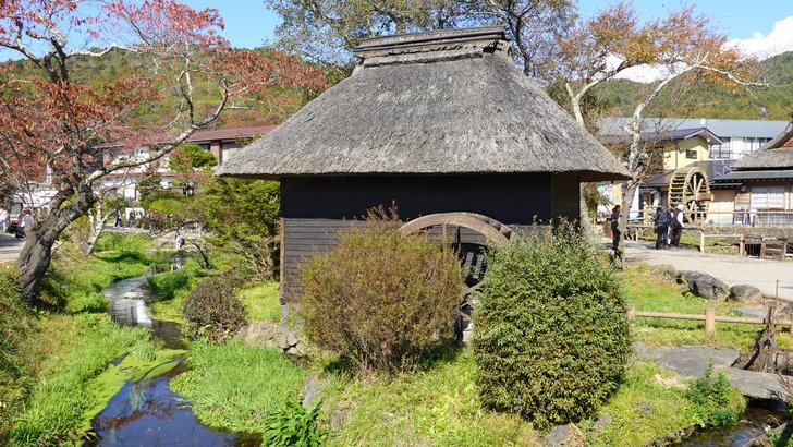 忍野村忍草の茅葺屋根の水車小屋と湧水の水路