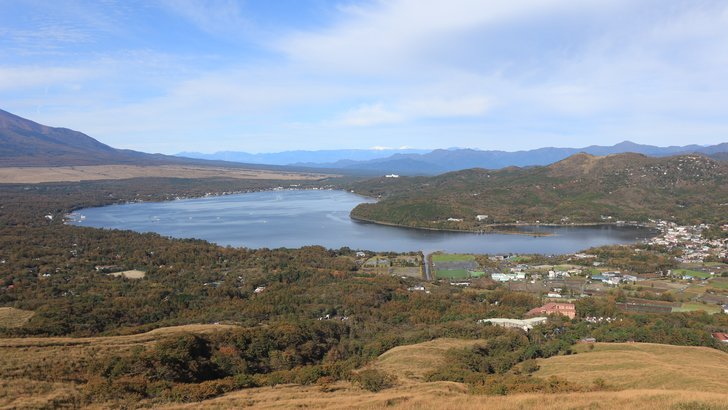 明神山から見下ろした山中湖。湖の周りに山中湖村の集落と森、その先に山並みが続く