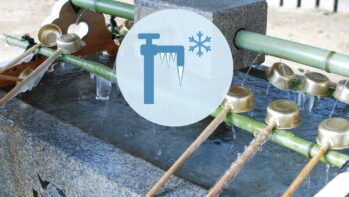 つららの下がった蛇口と雪の結晶のアイコン。背景は凍った神社の手水舎