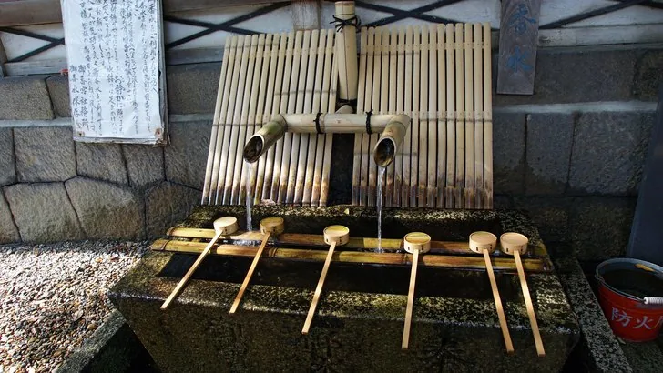 御香宮神社の水汲み場。竹の樋から水が注ぎ、柄杓が並ぶ